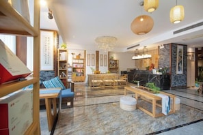 Una sala de estar moderna con chimenea, un comedor y una cocina visible al fondo.