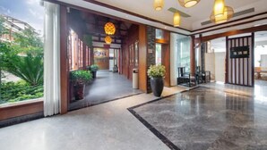 A hotel lobby with a marble floor, wooden accents, hanging lamps, and a view of greenery outside. - Baofeng Homestay (Zhangjiajie National Forest Park) (Zhangjiajie)