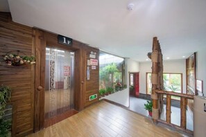Un vestíbulo de hotel con paneles de madera, un mostrador de recepción y una escalera.