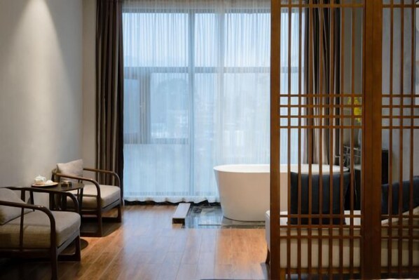Une chambre moderne dotée d’une grande fenêtre, d’une baignoire et d’une cloison en bois.