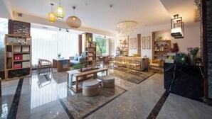A spacious living area with a large dining table, multiple seating options, and a variety of bookshelves. - Baofeng Homestay (Zhangjiajie National Forest Park) (Zhangjiajie)