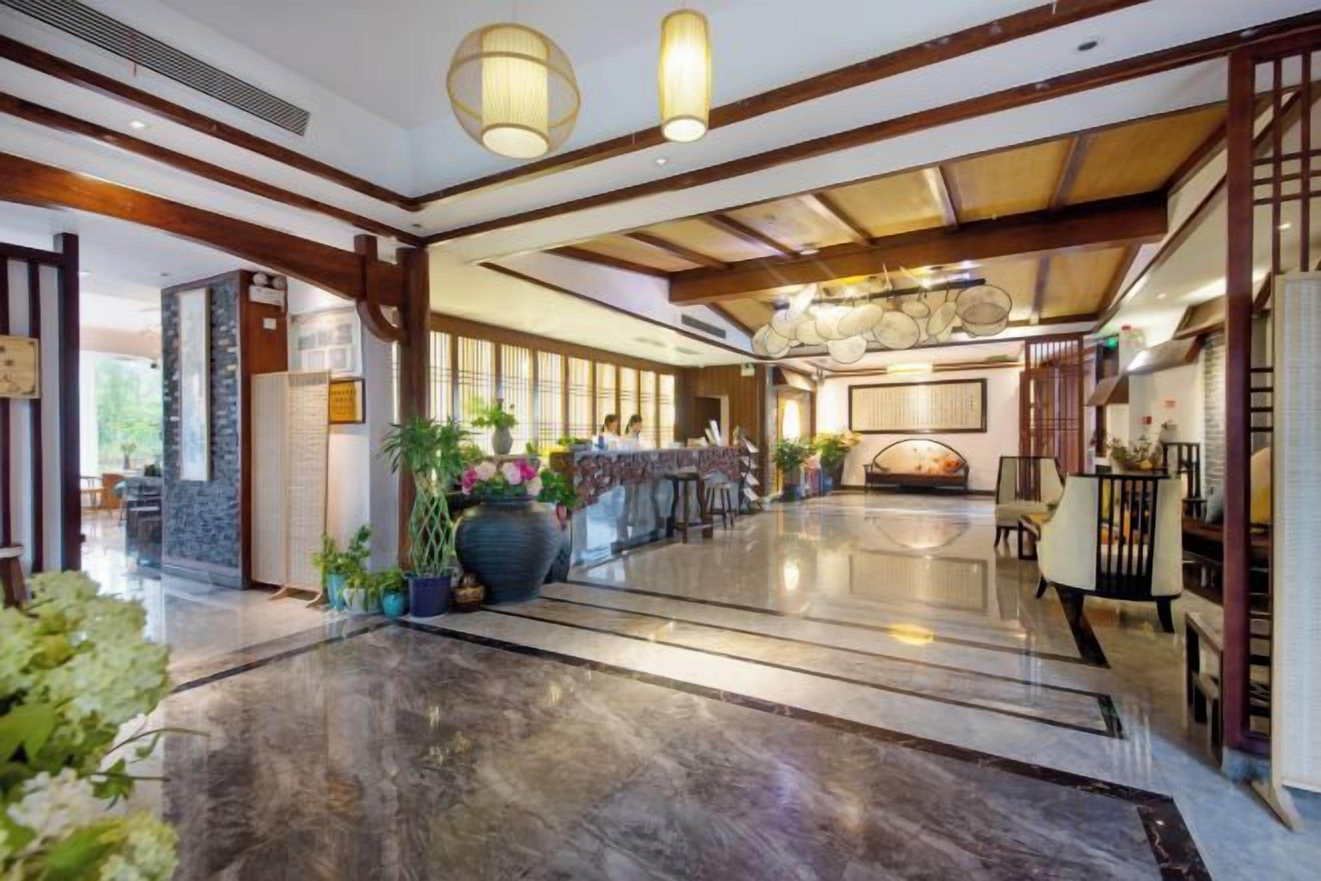 Un'ampia hall con pavimento lucido, una reception e un'area salotto.