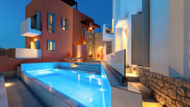 A modern building with a swimming pool, stone walls, and a balcony. - Island View - Elafi with Shared Pool (Ιαλυσός)