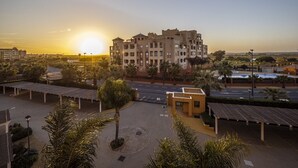 A multi-story hotel with a courtyard, palm trees, and a pool. - Los Albatros - Haraganes Beach HAHB174P170 (Isla Canela)
