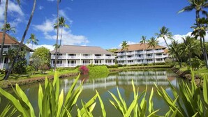 A hotel with multiple floors, a swimming pool, and palm trees. - Tranquil Retreat w/Split AC - Kiahuna 2052 (KOLOA)