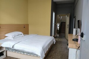 Una habitación de hotel con una cama, mesita de noche y vistas a una escalera.