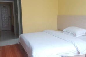 A room with a bed, a wooden floor, and a door. - Jinxin Hotel (Hezhou)