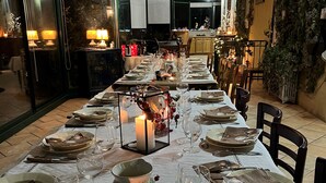 A long dining table set for a meal with candles, plates, and wine glasses.