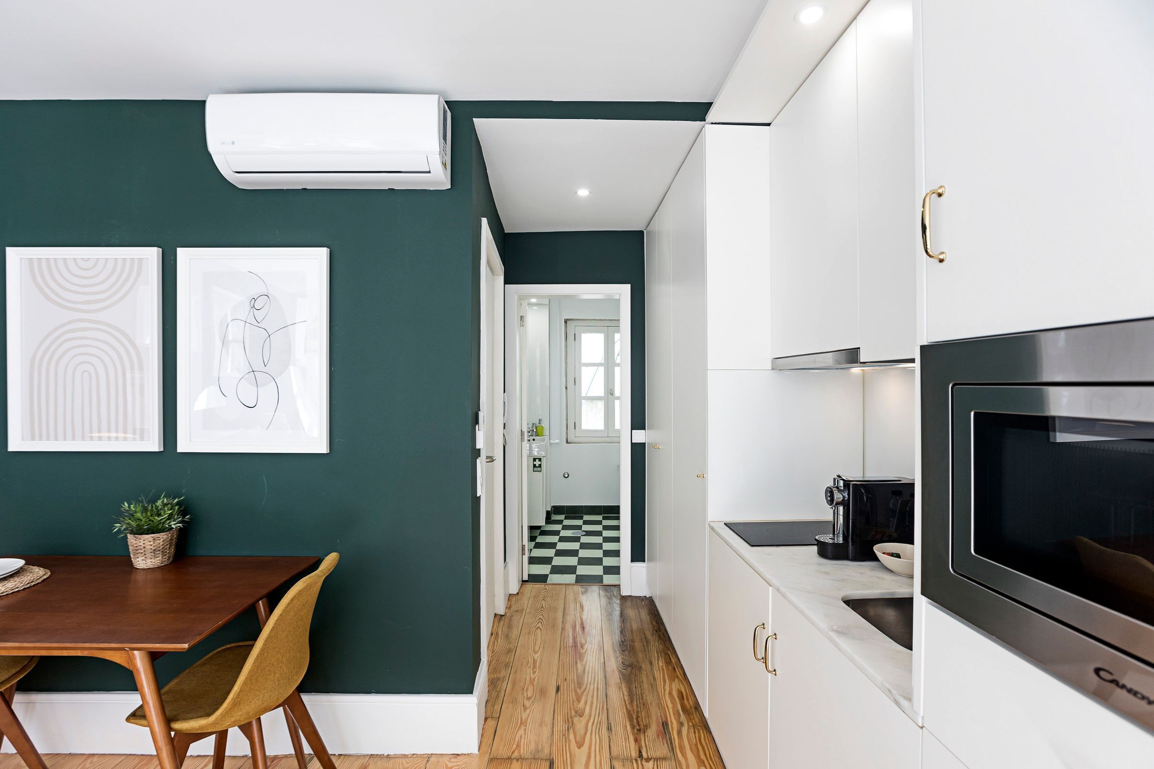 A modern kitchen with white cabinets, a black oven, and a checkered floor.