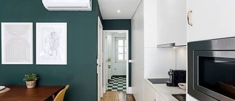 A modern kitchen with white cabinets, a black oven, and a checkered floor.