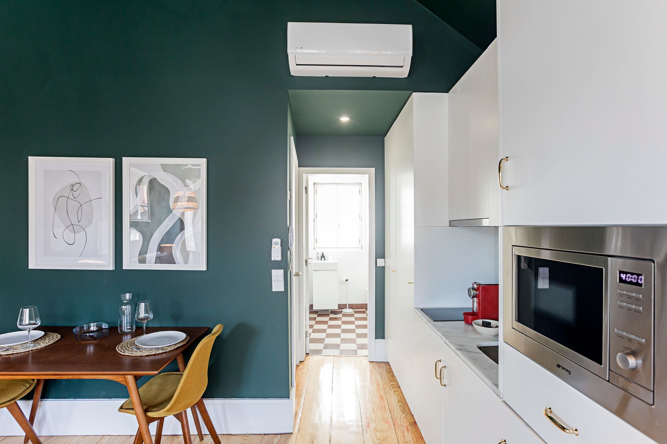 Una cucina moderna con mobili bianchi, un forno in acciaio inossidabile e un pavimento a scacchi.