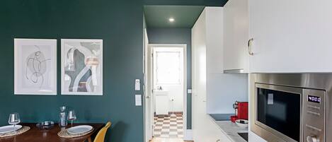 Una cucina moderna con mobili bianchi, un forno in acciaio inossidabile e un pavimento a scacchi.