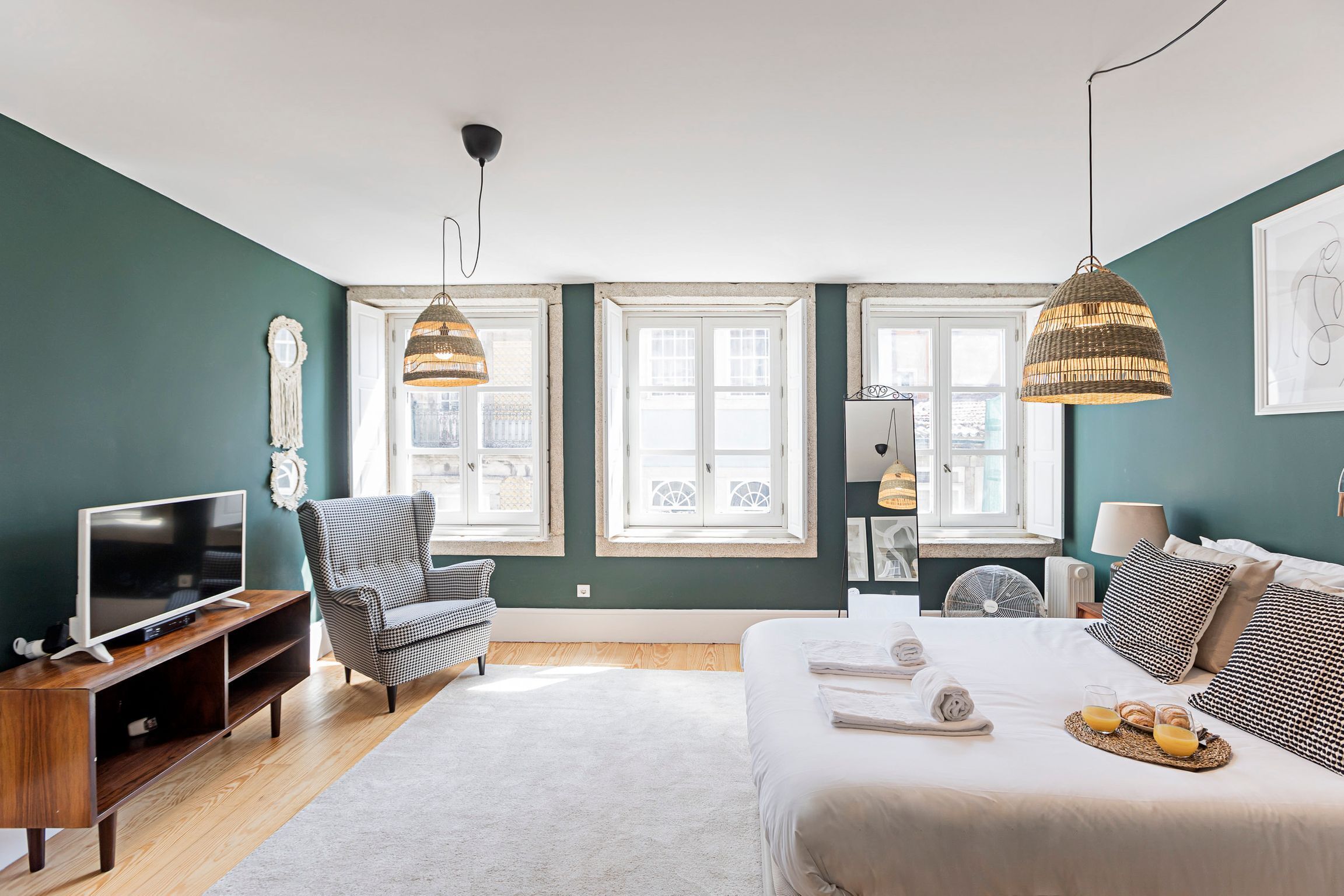 Une chambre d’hôtel moderne dotée d’un grand lit, d’une télévision, d’un fauteuil et d’un coin repas où le petit-déjeuner est servi.
