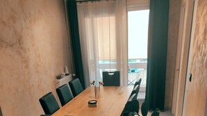 A dining area with a long wooden table, black chairs, and a potted plant. - Ideally located 70m2 T3 apartment with private balcony and secure parking (Saint-Priest)