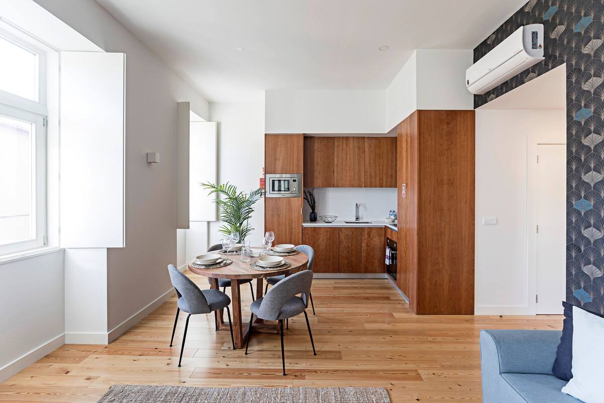 A modern apartment with a dining area, kitchen, and living space.