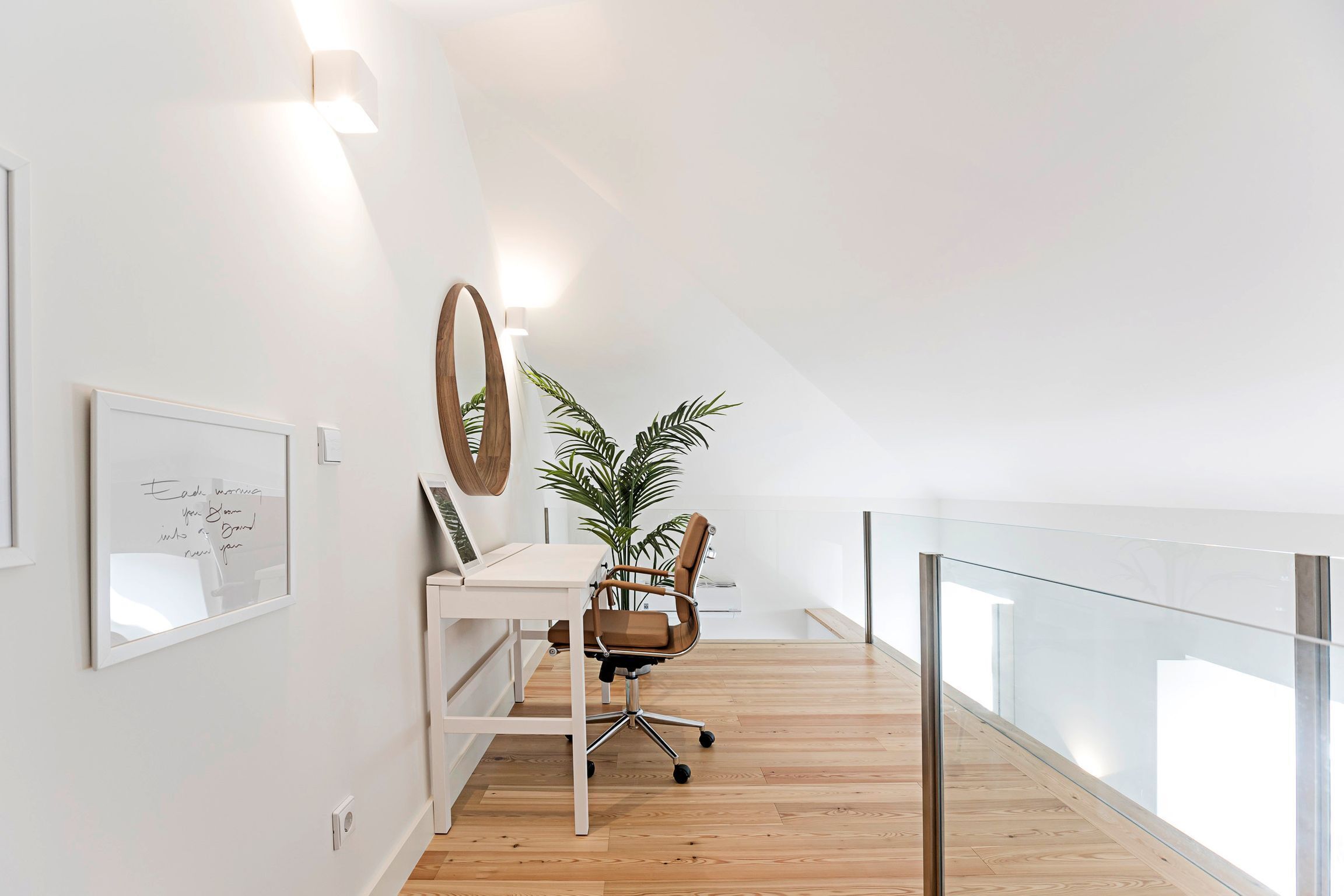 A modern office space with a desk, chair, and potted plant.
