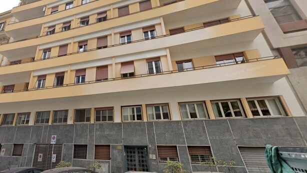 A multi-story building with balconies, large windows, and a ground-level entrance. - Le Petit Bijou (Rome)