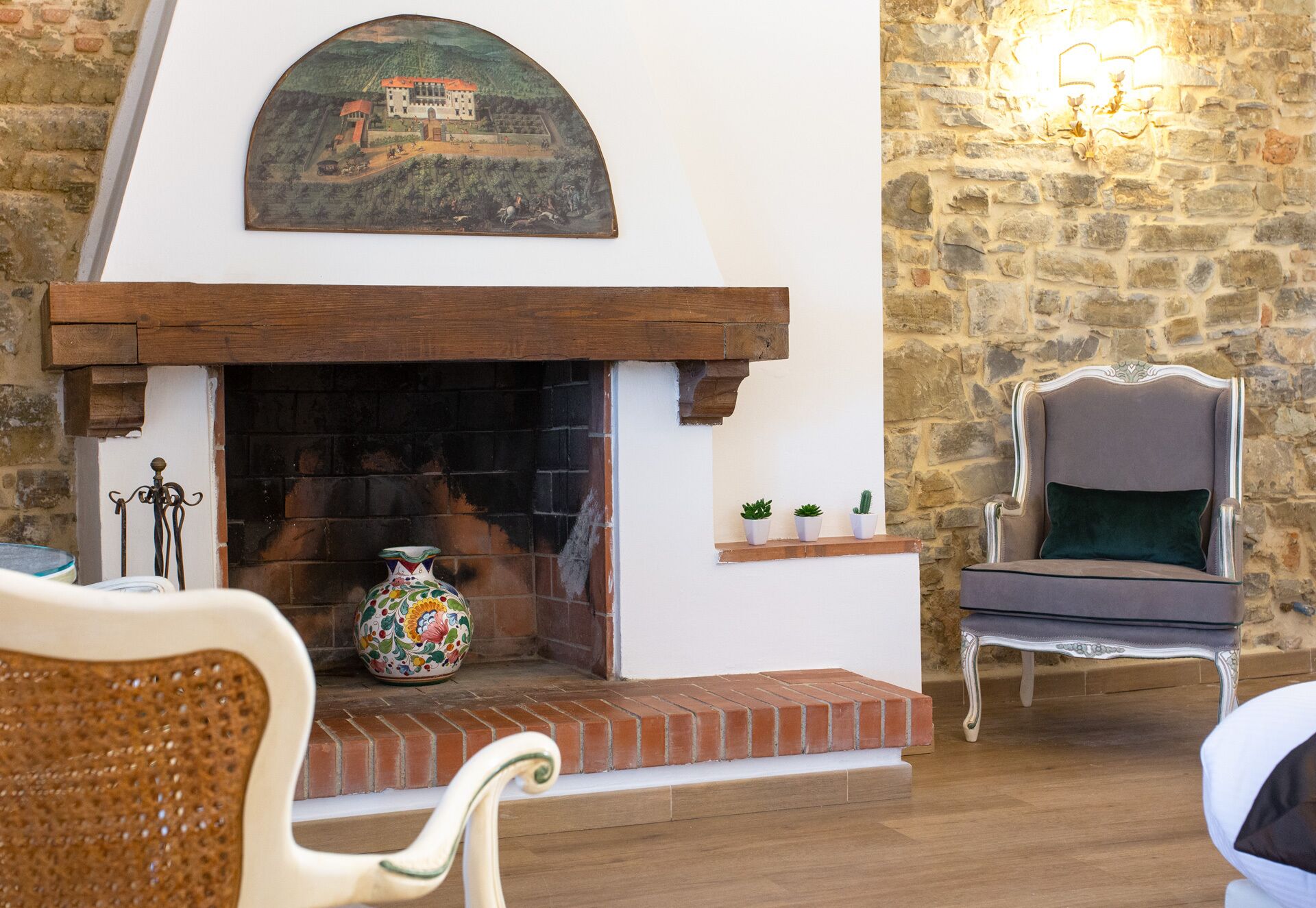 A cozy room with a fireplace, a stone wall, and a comfortable chair.