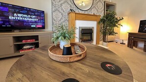 A living room with a television, a fireplace, a mirror, and a plant. - Central Bedford Apartment | Secure Parking | Fast Wi-Fi | Walk to Station (Bedford)