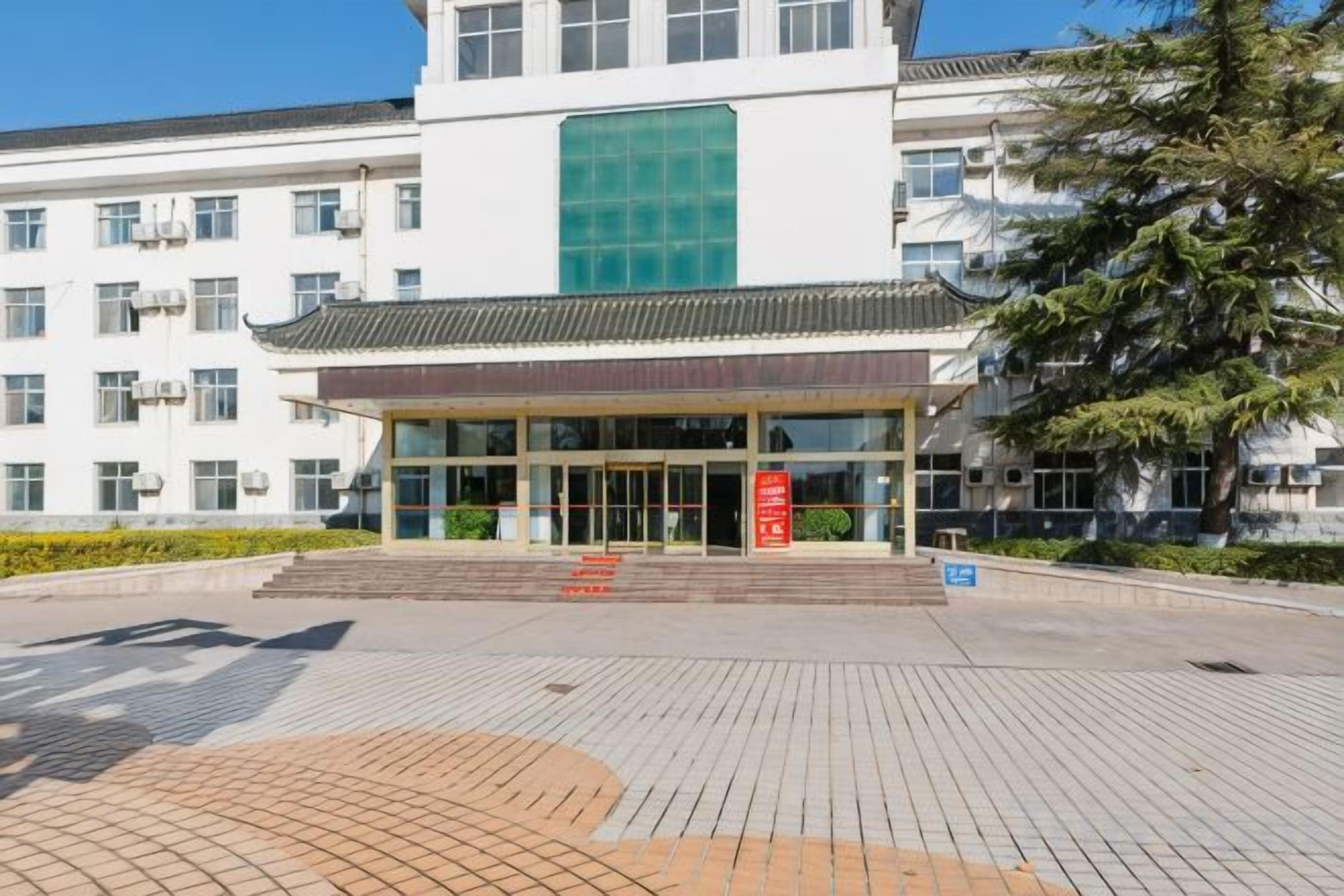 A building with a traditional architectural style, featuring a large entrance with glass doors and a tiled roof.