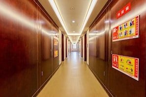 A long, narrow hotel corridor with wooden walls and a light-colored floor. - Guangrao Hotel (Guangrao)