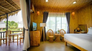 A room with a bed, wooden furniture, a table, and a chair. - Cantho Eco Resort (Can Tho)