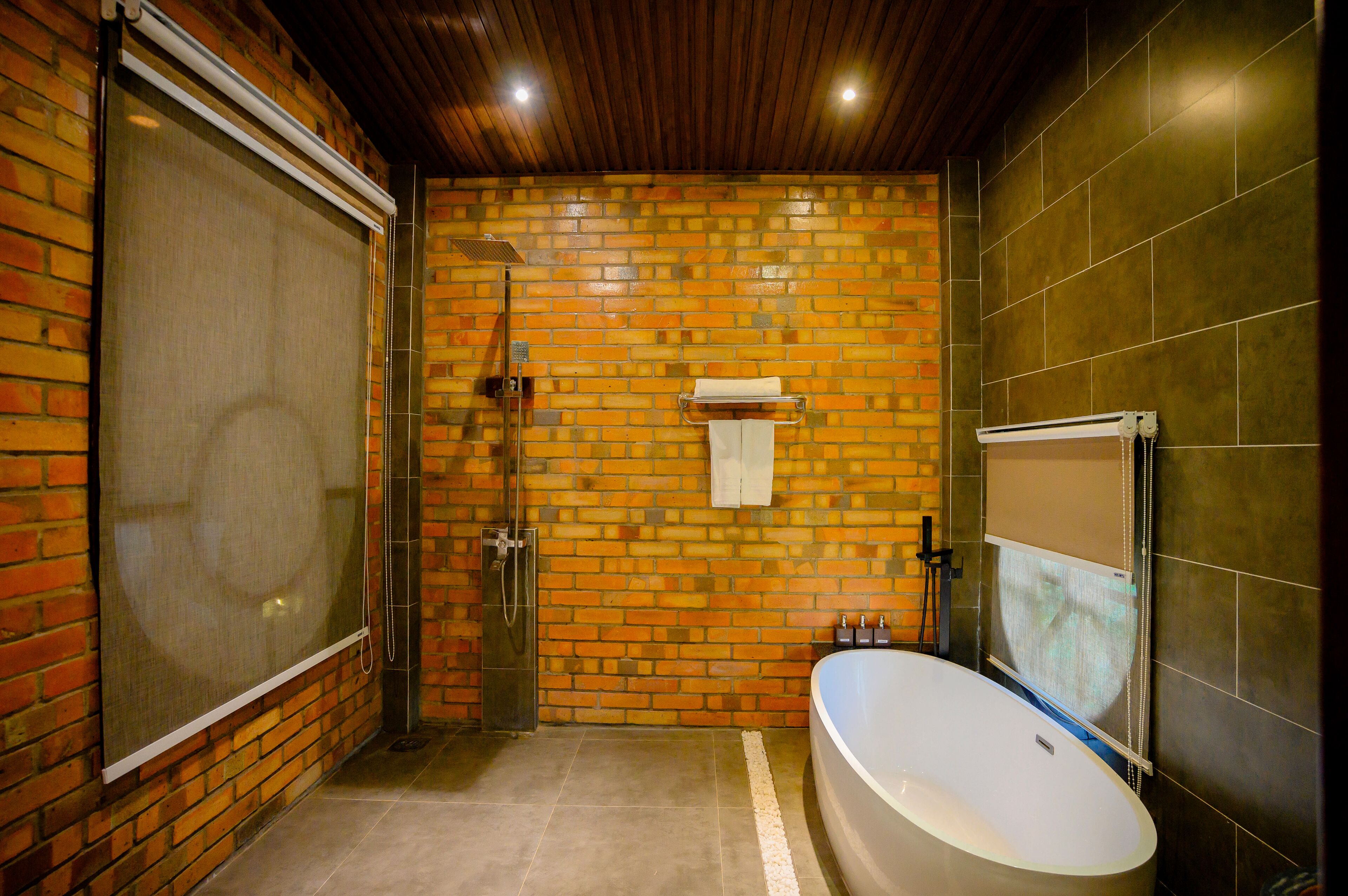 A bathroom with a shower, a bathtub, and a tiled wall.