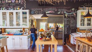 Un interior de restaurante con un menú en la pizarra, armarios de madera y una mesa de comedor central.