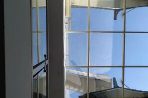 A window with a grid pattern, a metal railing, and a clear blue sky. - Dali Ancient Town No. 204 Ideal Youth Hostel (Dali City)