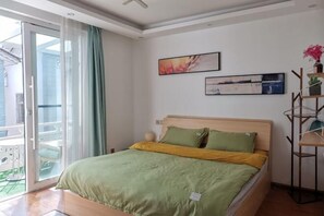 A bedroom with a bed, a sliding glass door to a balcony, and two framed artworks on the wall. - Dali Ancient Town No. 204 Ideal Youth Hostel (Dali City)