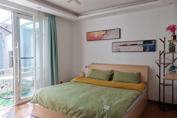 A bedroom with a bed, a sliding glass door to a balcony, and two framed artworks on the wall. - Dali Ancient Town No. 204 Ideal Youth Hostel (Dali City)