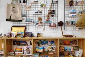 A display of postcards and a framed certificate on a wooden shelf. - Dali Ancient Town No. 204 Ideal Youth Hostel (Dali City)