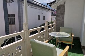 A balcony with a white railing, a round table, and two chairs. - Dali Ancient Town No. 204 Ideal Youth Hostel (Dali City)