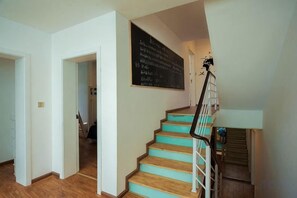 A staircase with wooden steps and a metal railing, leading to a landing with a blackboard. - Dali Ancient Town No. 204 Ideal Youth Hostel (Dali City)