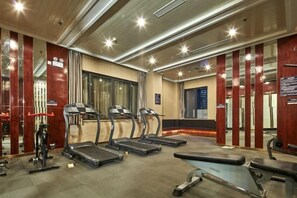 A gym with treadmills, exercise equipment, and a reception desk. - Jiejiao 33 Qinglv Hotel (Chongqing)