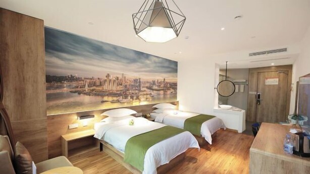 A hotel room with two beds, a wooden floor, a cityscape mural, a round light fixture, and a desk with a chair. - Jiejiao 33 Qinglv Hotel (Chongqing)