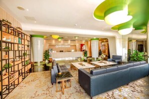 A modern lobby with seating areas, a reception desk, and decorative plants. - Jiejiao 33 Qinglv Hotel (Chongqing)