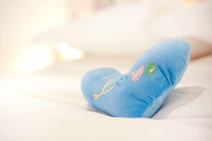 Ein blaues Kopfkissen mit eingestickten Mustern auf einem Bett.