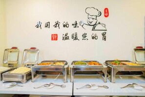 A buffet setup with multiple serving stations, each with a variety of dishes. - General Fenghua (Lijiang) Travel Center (Lijiang)