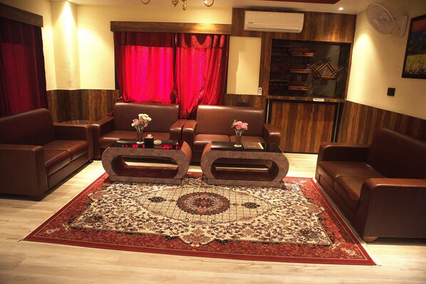 A living room with a large rug, leather sofas, and a coffee table.