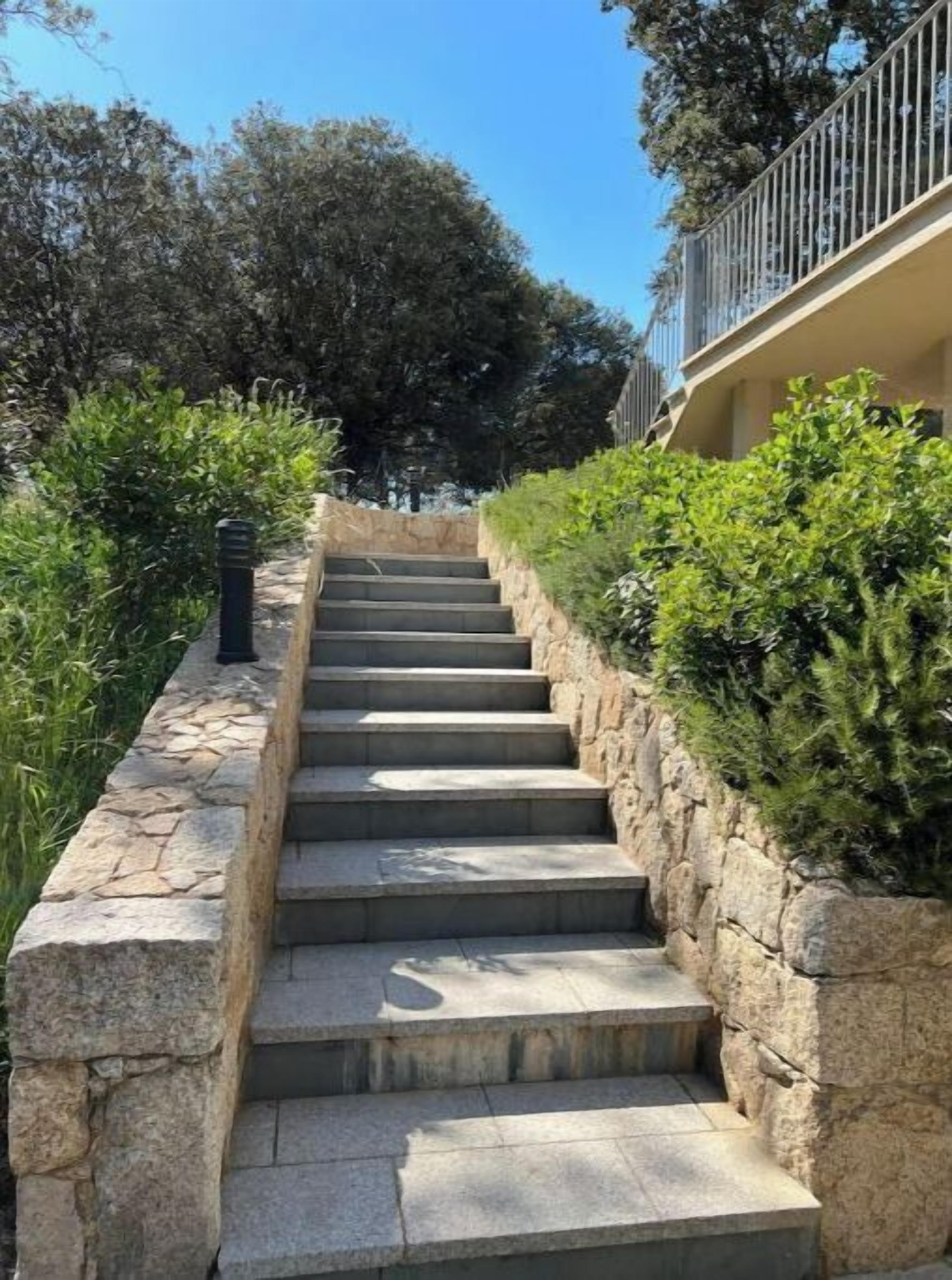 A set of stone steps leading up to a building with a balcony.