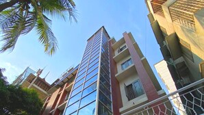 A multi-story building with a modern architectural design, featuring large windows and a balcony with a decorative railing. - Crown Palace Residence (Dhaka)