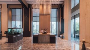 A spacious lobby with a reception desk, large windows, and a modern chandelier. - Zhenhe Yiting Hotel (Ningbo)
