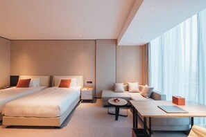 A modern hotel room with two beds, a sofa, a small table, and a large window with curtains. - Zhenhe Yiting Hotel (Ningbo)