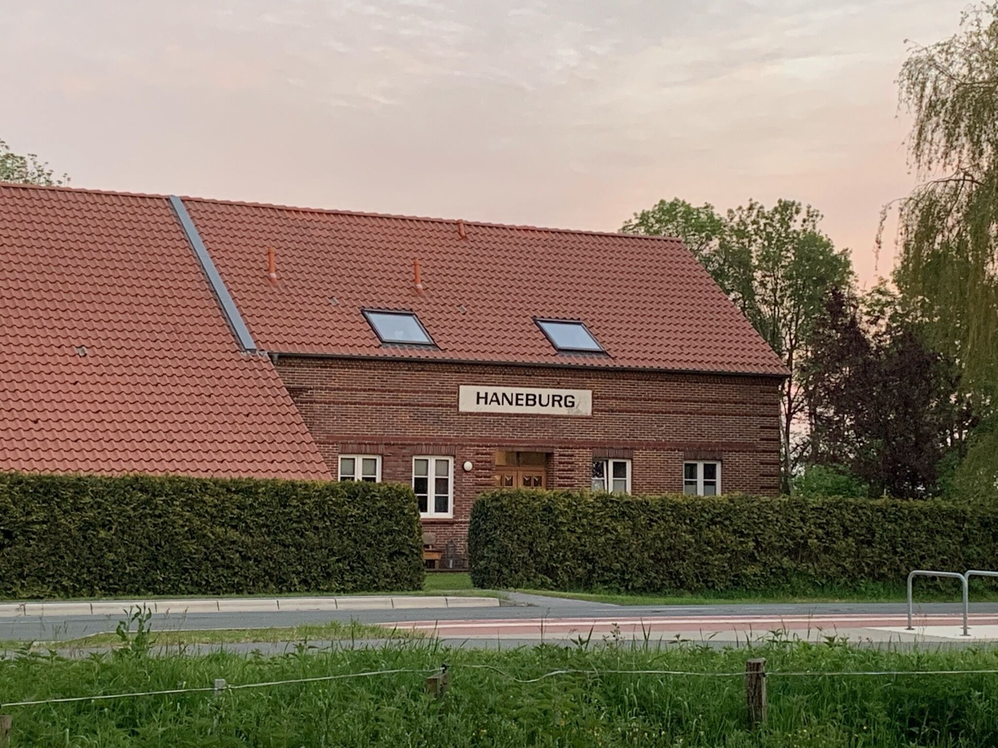 A two-story building with a red-tiled roof and a sign that reads "HANEBURG."