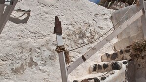A staircase with a wooden handrail leading up a sandy slope. - Traditional Farmers Secret Cave #2 Santorini (Emporio)