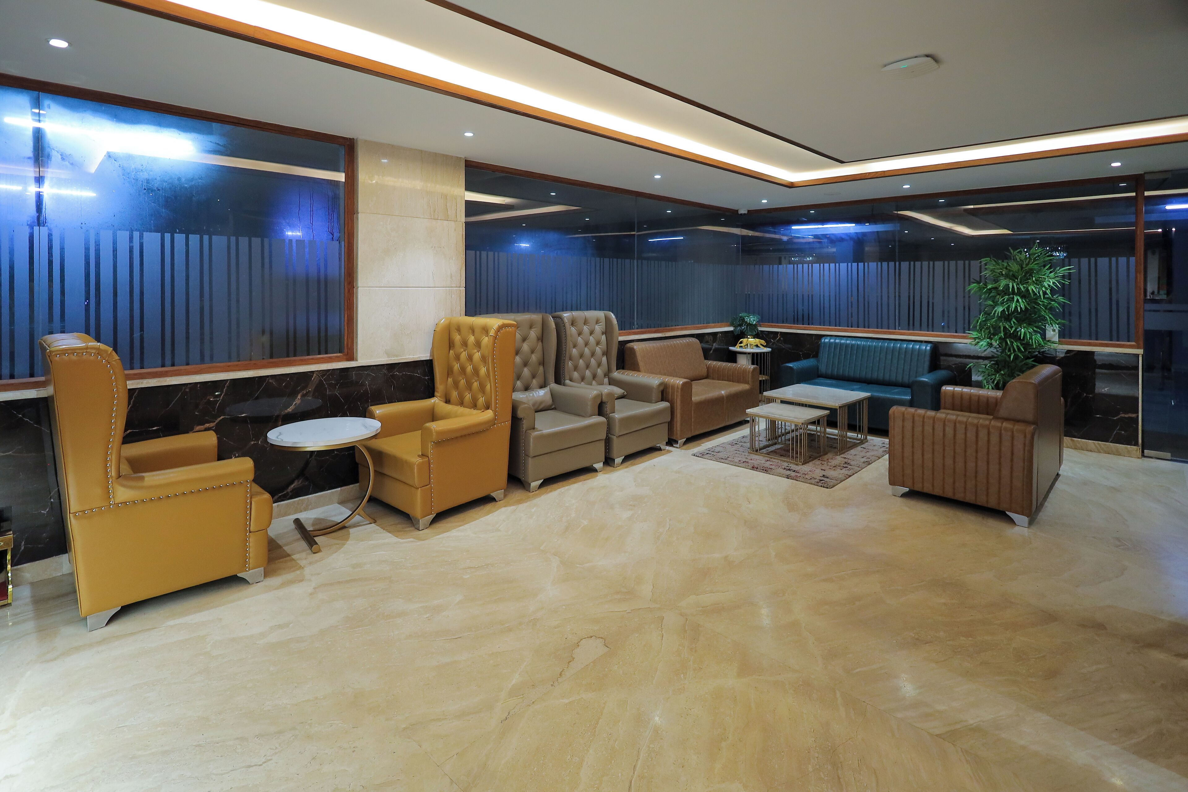 Eine moderne Lounge mit Ledersofas, einem Couchtisch und einer Topfpflanze.