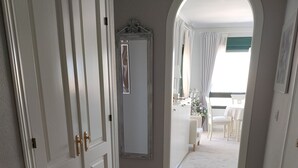 Un pasillo con alfombra que conduce a un comedor con una mesa y sillas.