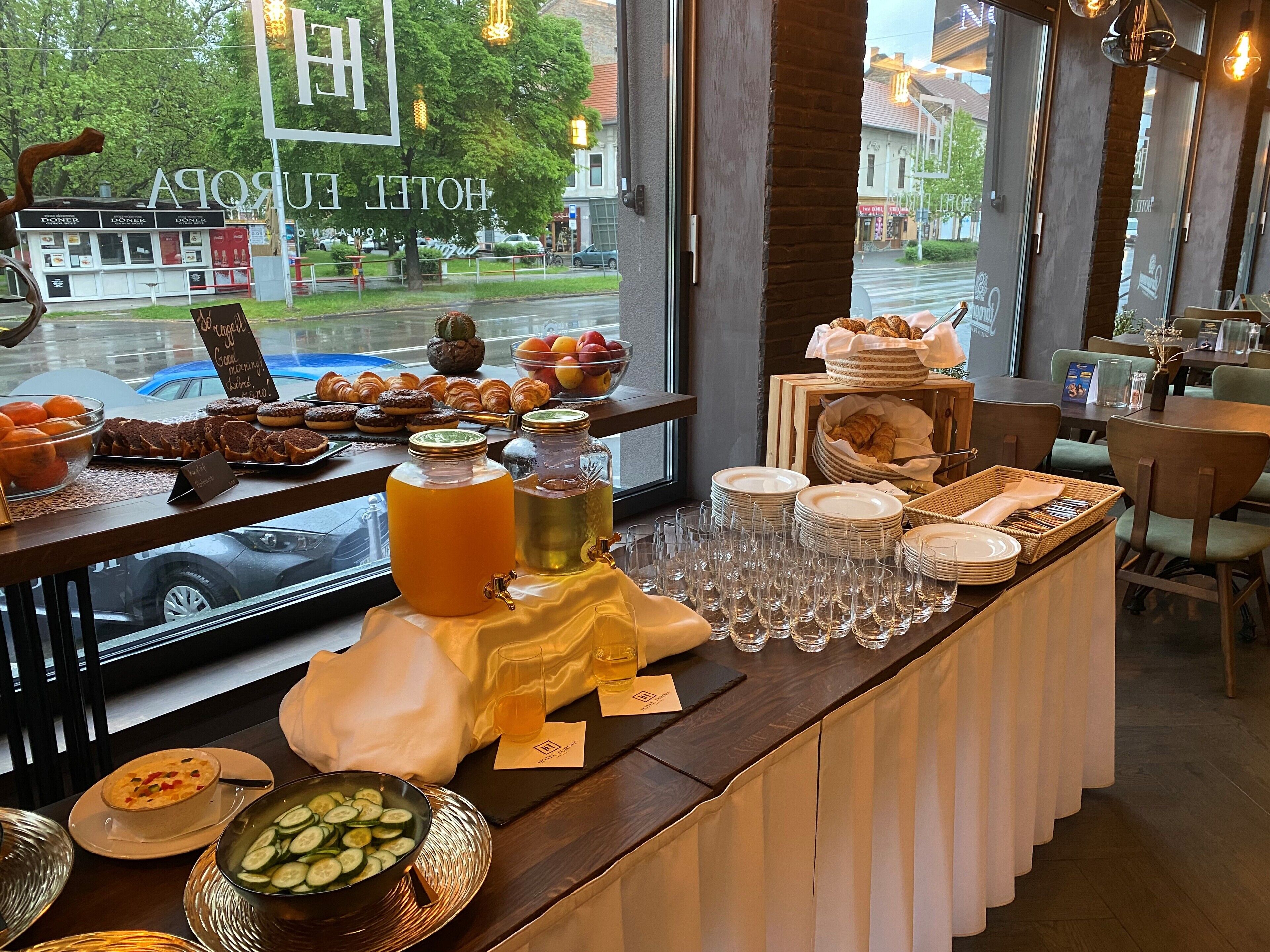 A breakfast buffet with various pastries, fruits, and beverages.