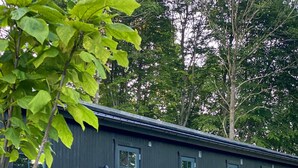 A row of cabins with numbered doors, wooden railings, and gravel pathways. - Rallarhustruns (Hassleholm)